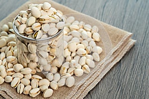 Pistachio nuts in transparent glass jar on a wooden table. Healthy food high protein