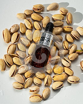 Pistachio oil in a glass bottle with nuts on a white background. Natural cosmetics on a white background. Aroma oils.