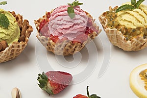 Pistachio pation fruit and strawberry ice creams on white background with accompanying fruits