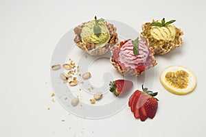 Pistachio pation fruit and strawberry ice creams on white background with accompanying fruits