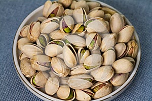 Pistachio in a plate isolate on blue background