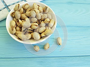 Pistachios on blue wooden plate, towel roasted