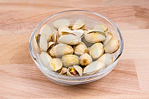 Pistachios on bowl on beech wood