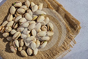 Pistachios in burlap sack on concrete table. Organic pistachios. Vegan Healthy food high protein. Dietary nutrition