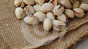 Pistachios in burlap sack on concrete table. Organic pistachios. Vegan Healthy food high protein. Dietary nutrition