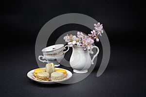 Pistachios and orange macaroons arranged on a black background