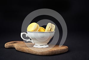 Pistachios and orange macaroons arranged on a black background