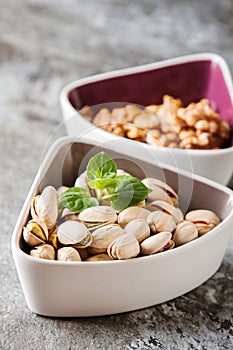 Pistachios in shell walnuts and mint, against a light background