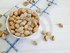 pistachios on a white wooden plate, towel