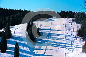 Piste ski tracks on snowy and sunny mountain side