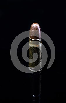 Pistol bullet. Metal case. Old ammunition. Cartridge on a black background. Macro shot of a bullet.