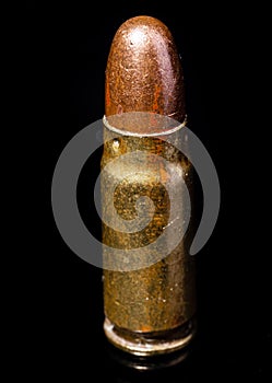 Pistol bullet. Metal case. Old ammunition. Cartridge on a black background. Macro shot of a bullet.