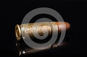 Pistol bullet. Metal case. Old ammunition. Cartridge on a black background. Macro shot of a bullet.