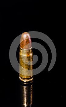 Pistol bullet. Metal case. Old ammunition. Cartridge on a black background. Macro shot of a bullet.