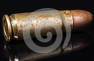 Pistol bullet. Metal case. Old ammunition. Cartridge on a black background. Macro shot of a bullet.