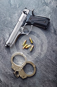 Pistol bullets, handgun and handcuffs.