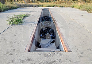 Pit for car maintenance. Garbage in the garage.
