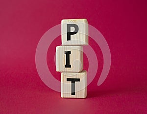 PIT - Personal Income Tax symbol. Wooden cubes with words PIT. Beautiful red background. Business and PIT concept. Copy space
