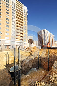 Pit for sewerage with water near building under construction