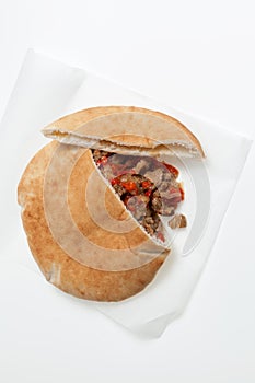 Pita or Arabic bread, stuffed with meat and vegetables on light background. Close-up, selective focus, copy space