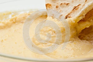 Pita bread dipped in humus photo