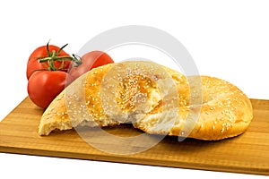 Pita bread and tomatoes on wooden board isolated on white background