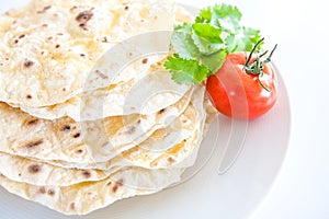 Pita bread on a white background with a tomato