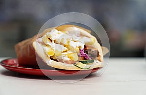 Pita souvlaki cooked for lunch in Greek restaurant. Traditional street food meal cooked on grill and served on plate