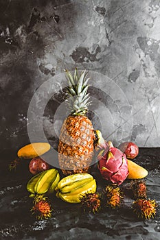 pitaya, rambutans, carambolas, mangoes, papayas and passion fruits on marble tabletop