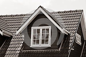 pitched roof dormer loft with white window and concrete tiles