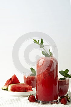 a pitcher full of a fruitie next to watermelon