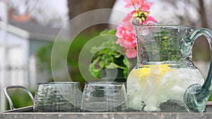 Pitcher of lemon water on table in backyard