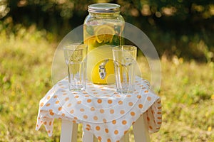 pitcher of lemonade and two glasses on the table, a summer picnic