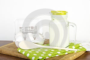 Pitcher of Milk with a carton of eggs with whisk