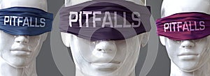 Pitfalls can blind our views and limit perspective - pictured as word Pitfalls on eyes to symbolize that Pitfalls can distort photo