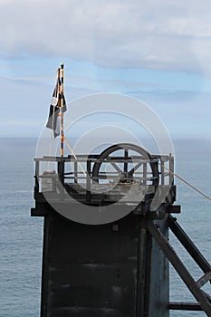 The pithead of a Cornish tin mine showing the main lifting pulley, with a Cornish nationalist Kernow flag