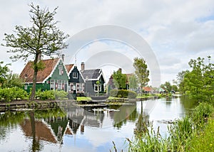 Pitoresque old dutch houses with clouded sky and a river in char