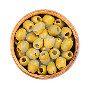 Pitted green olives for snacking, ready to eat, in a wooden bowl