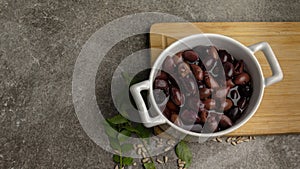 Pitted kalamon olives in bowl on rustic