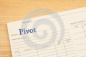 Pivot project plan folder on a wood desk