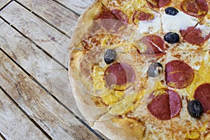 pizza abi - tomato sauce, cheese, salami, egg, olives with on wooden table