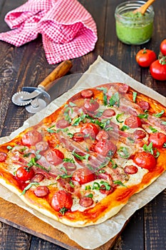 Pizza with bacon, sausage, mozzarella, tomatoes and basil. Italian cuisine. Recipe