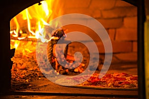 Pizza baking in wood fired oven photo