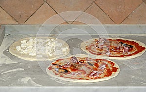 Pizza being baked in a wood fire brick oven in a restaurant