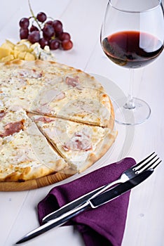 Pizza bianca with chicken, ham and cream sauce on a wooden board