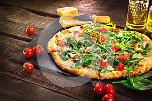 Pizza Caprese with arugula, cheese, yoghurt and cherry tomatoes