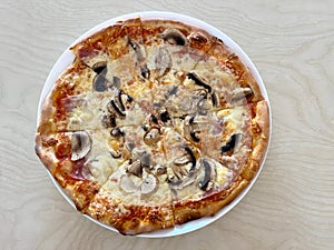 Pizza Capriciosa on a plate close-up on the table