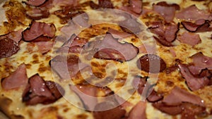 Pizza carnivor made of bacon, sausage and ham. Fast-food photography detail view of a pizza in a delivery box. Home delivered food