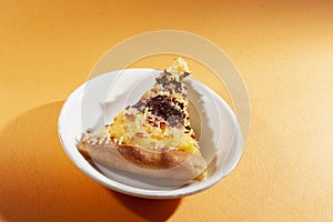 Pizza, with cheese and chocolate sprinkles, on orange background