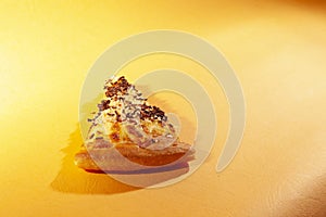 Pizza, with cheese and chocolate sprinkles, on orange background